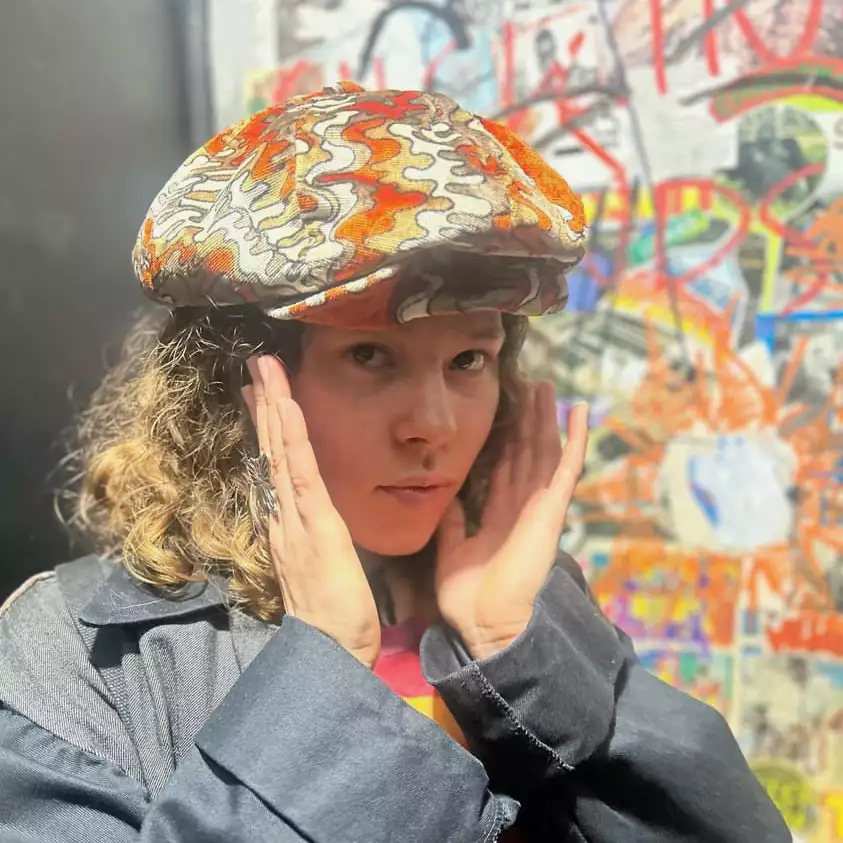 Headshot of Chia Kali wearing a colourful hat
