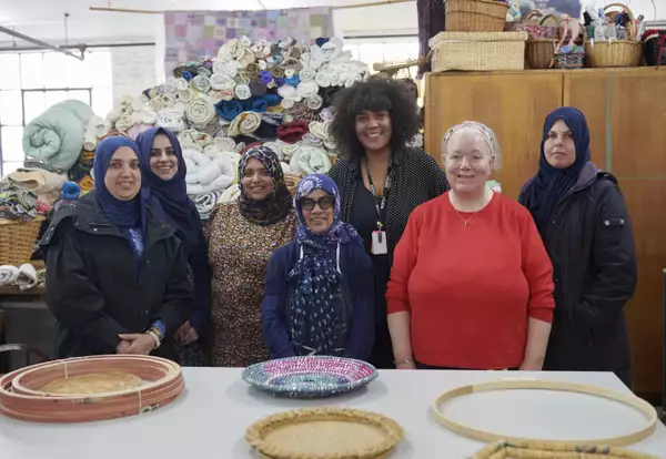 Seven people smiling in a workshop