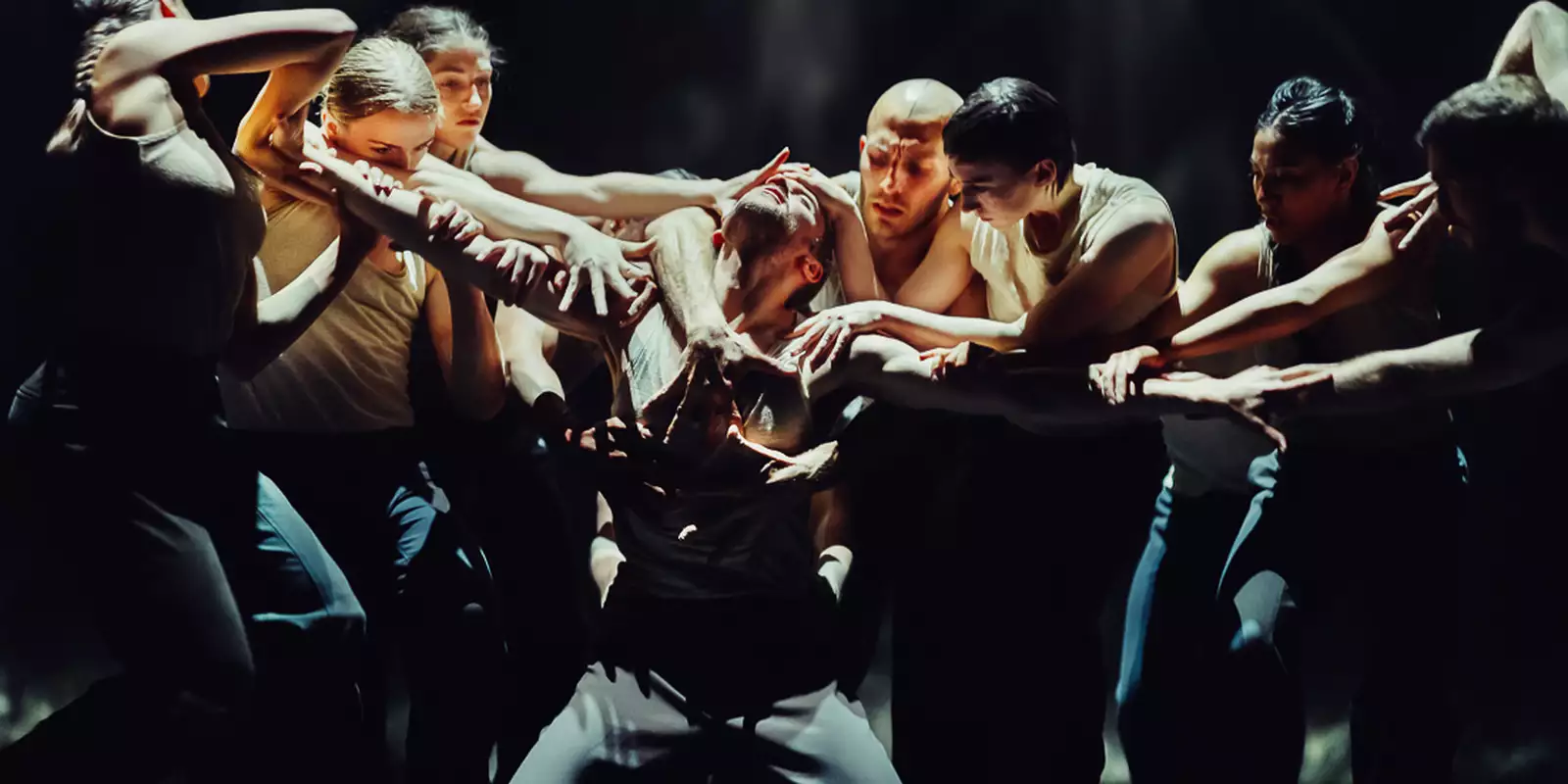 A still from Figures in Extinction [1.0] showing a performer being surrounded and grabbed by a group of performers