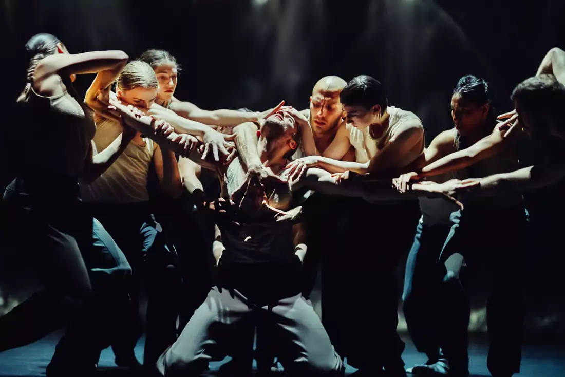 A still from Figures in Extinction [1.0] showing a performer being surrounded and grabbed by a group of performers