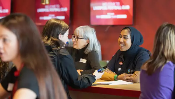 A mentor talking to a younger mentee during a speed mentoring session