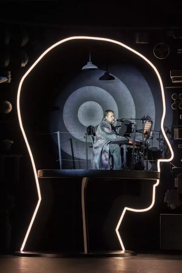 A photo of singer/musician John Grant in a structure shaped like the outline of a human head