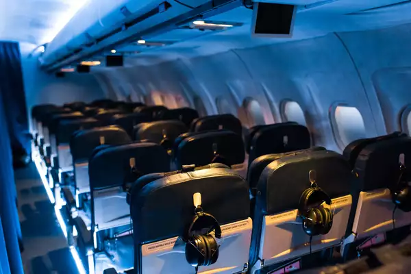 The inside of an aeroplane cabin as part of the FLIGHT experience. The lighting is blue.
