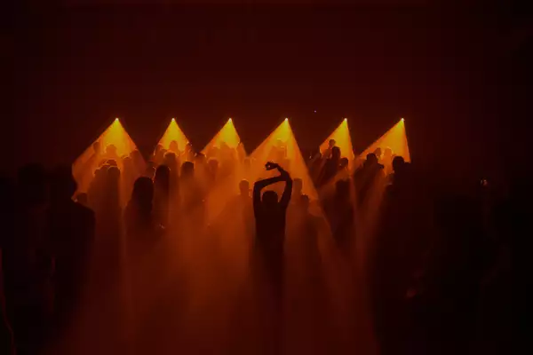 A crowd of people dancing in a low lit room