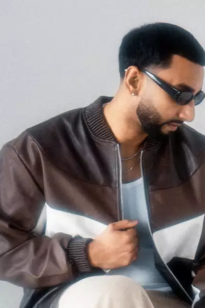 Headshot of Sagan wearing sunglasses and a brown jacket